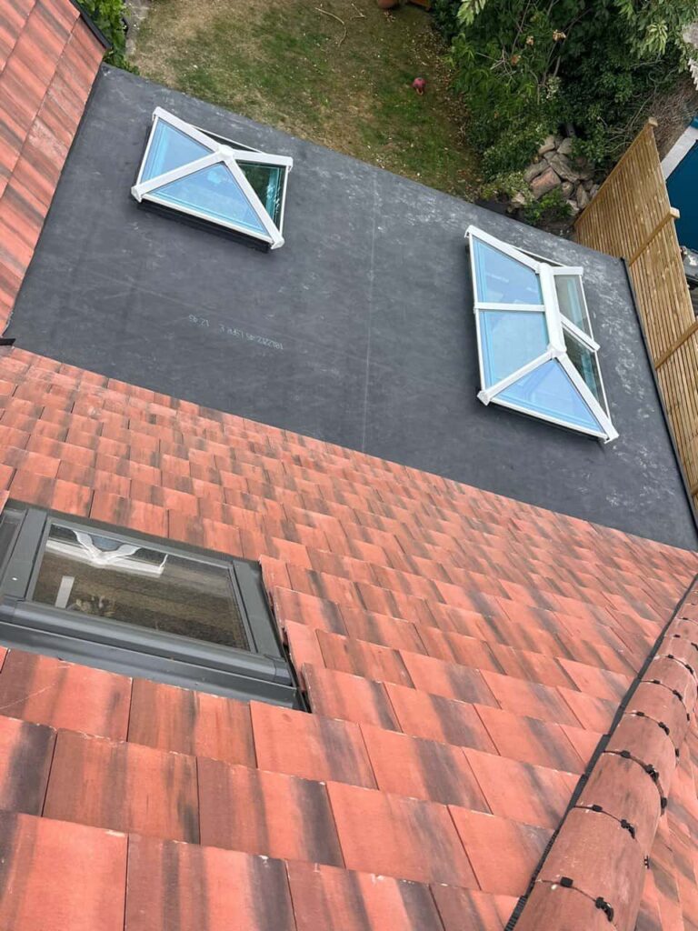 This is a photo taken from the roof ridge looking down a tiled pitched roof on to a flat roof. Works carried out by Dinnington Roofing Repairs